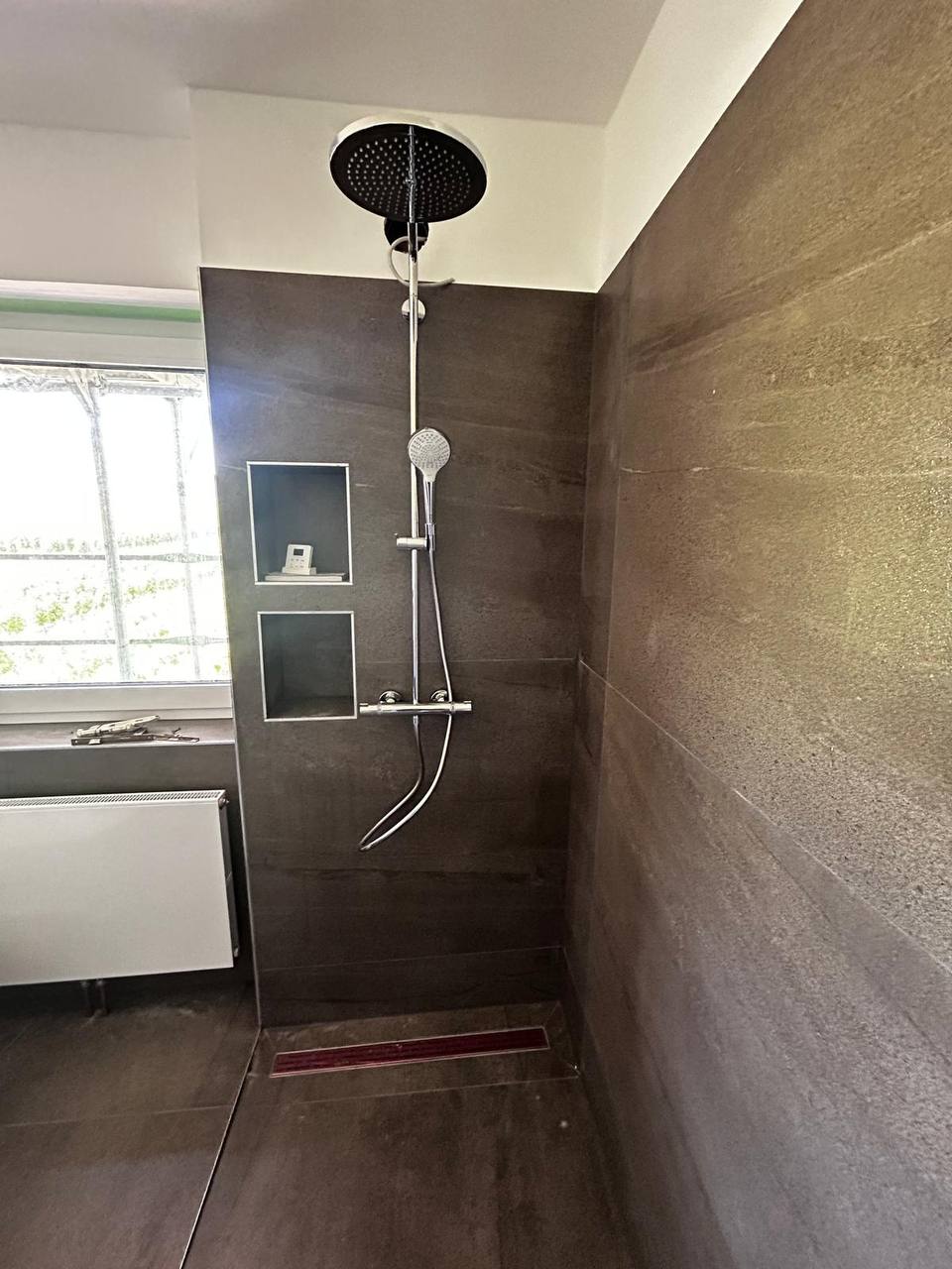 Moderne Dusche mit dunklen Fliesen